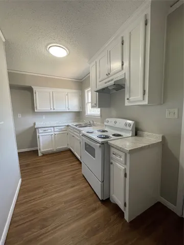 a kitchen with a white cabinets stove top oven and sink