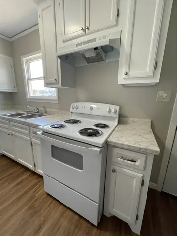 a white stove top oven sitting inside of a kitchen