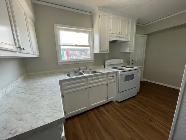 a kitchen with cabinets wooden floor and a sink