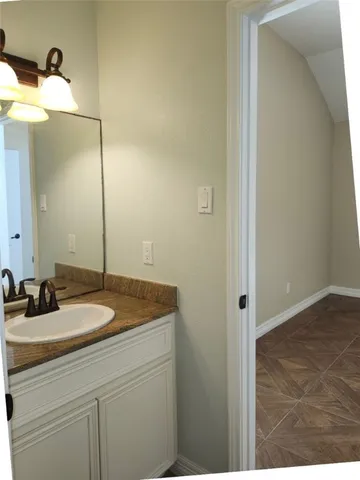 a bathroom with a granite countertop sink and a mirror
