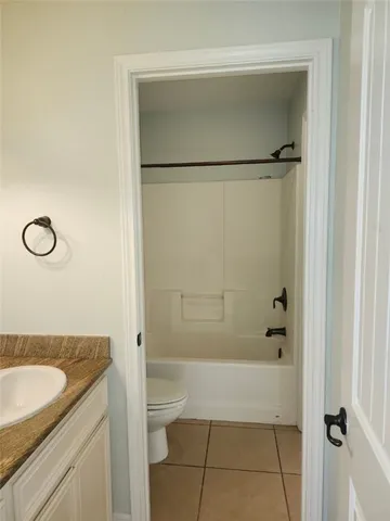 a bathroom with a granite countertop sink a mirror and a bathtub