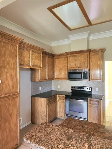 a kitchen with stainless steel appliances granite countertop a stove a sink and a microwave