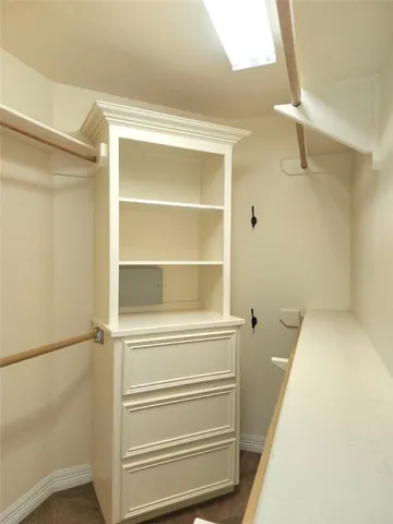 a view of walk in closet with empty racks