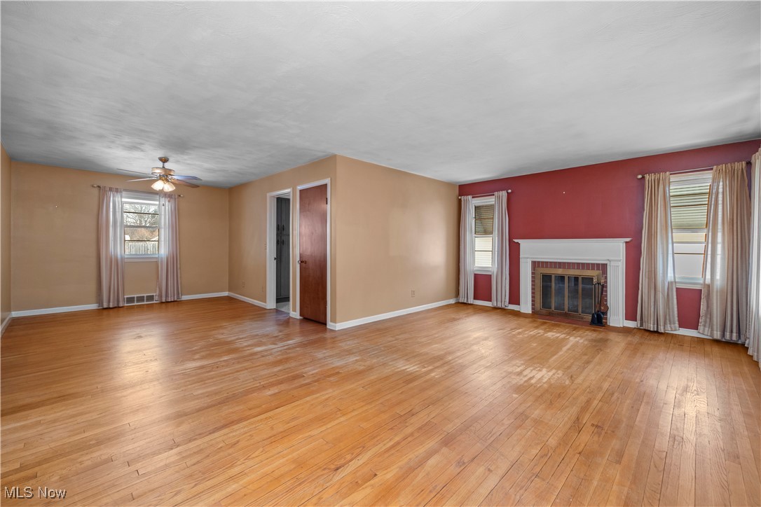 25950 Bagley Road Olmsted Falls, OH 44138 - Photo 8 of 32 Unfurnished living room with light wood-style floors, a fireplace, and a ceiling fan