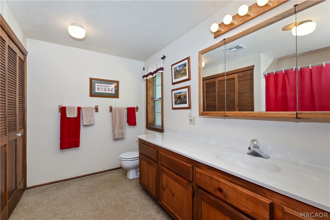 691 Cottage Grove Road Lake Arrowhead, CA 92352 - Photo 25 of 28 a bathroom with a sink a mirror and a toilet