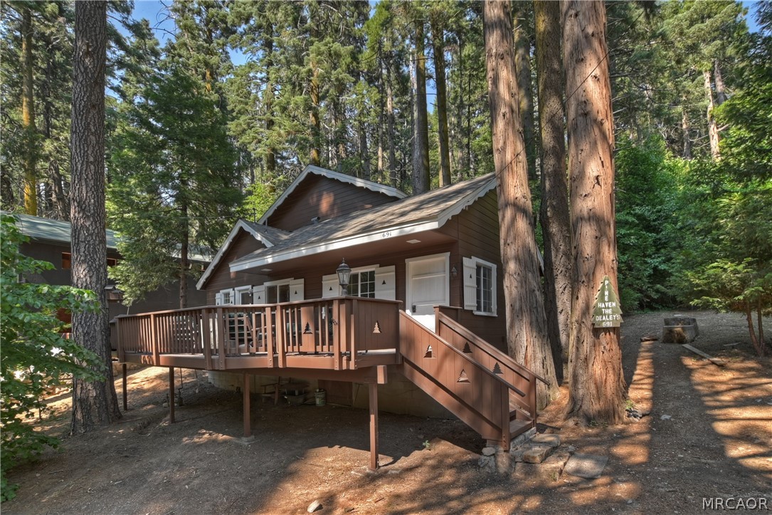 691 Cottage Grove Road Lake Arrowhead, CA 92352 - Photo 5 of 28 a backyard of a house with table and chairs