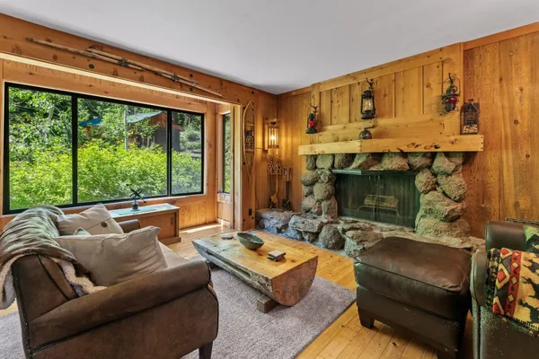 a living room with furniture a fireplace and a floor to ceiling window