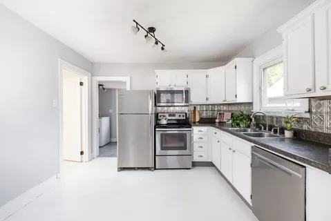 a kitchen with stainless steel appliances a refrigerator sink and cabinets