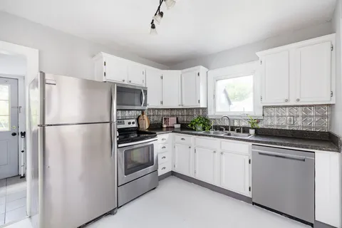 a kitchen with white cabinets and white appliances
