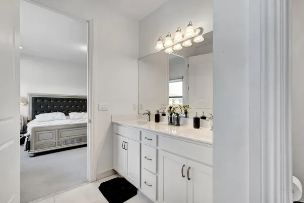 a en suite bathroom with a double vanity sink and a mirror