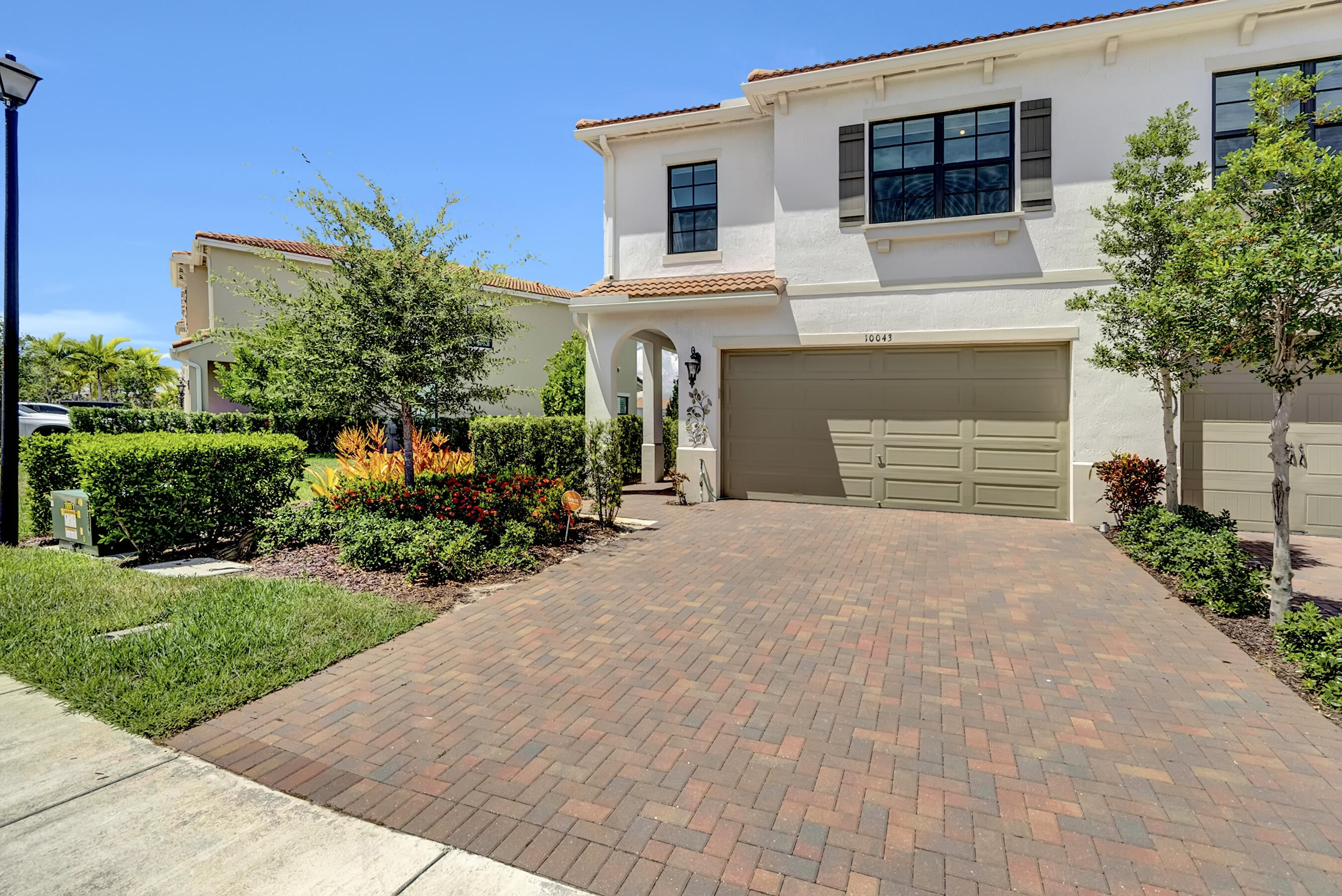 10043 Akenside Drive Boca Raton, FL 33428 - Photo 2 of 30 a front view of a house with a garden