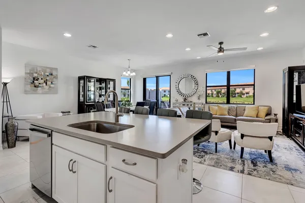 a kitchen with granite countertop a sink and white cabinets with wooden floor