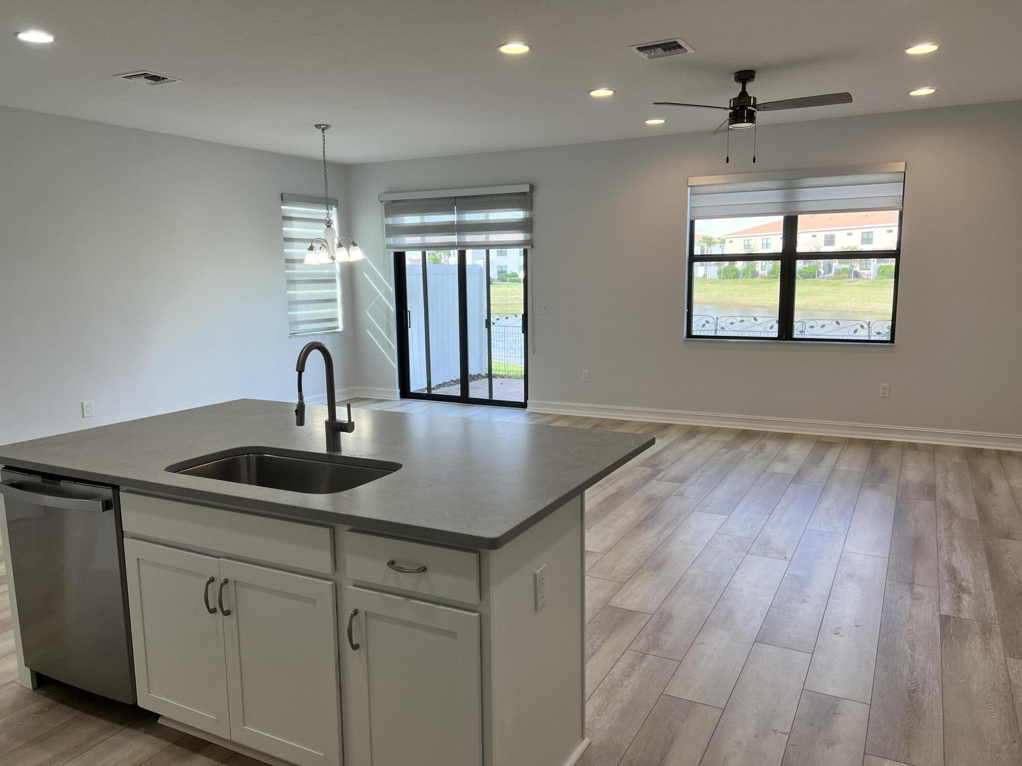 10043 Akenside Drive Boca Raton, FL 33428 - Photo 5 of 30 a kitchen with stainless steel appliances granite countertop a sink a window and wooden floor