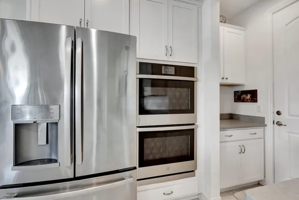 a kitchen with white cabinets and stainless steel appliances