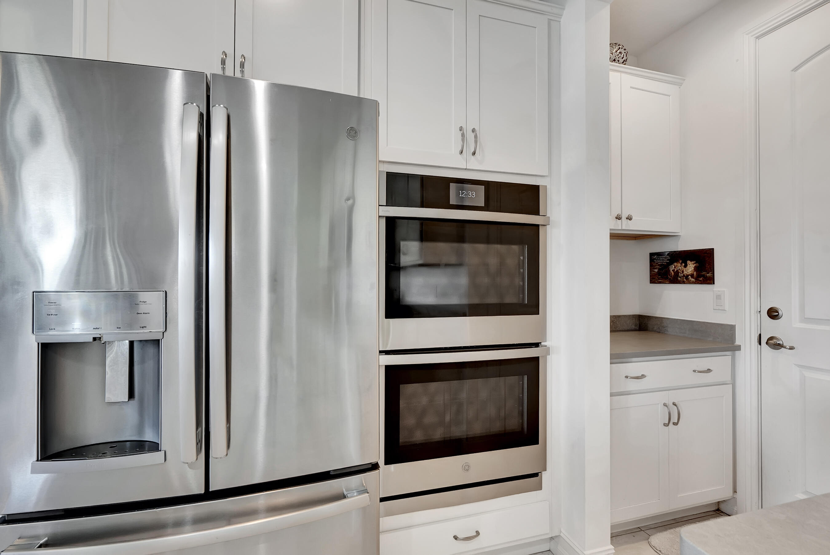 10043 Akenside Drive Boca Raton, FL 33428 - Photo 8 of 30 a kitchen with white cabinets and stainless steel appliances