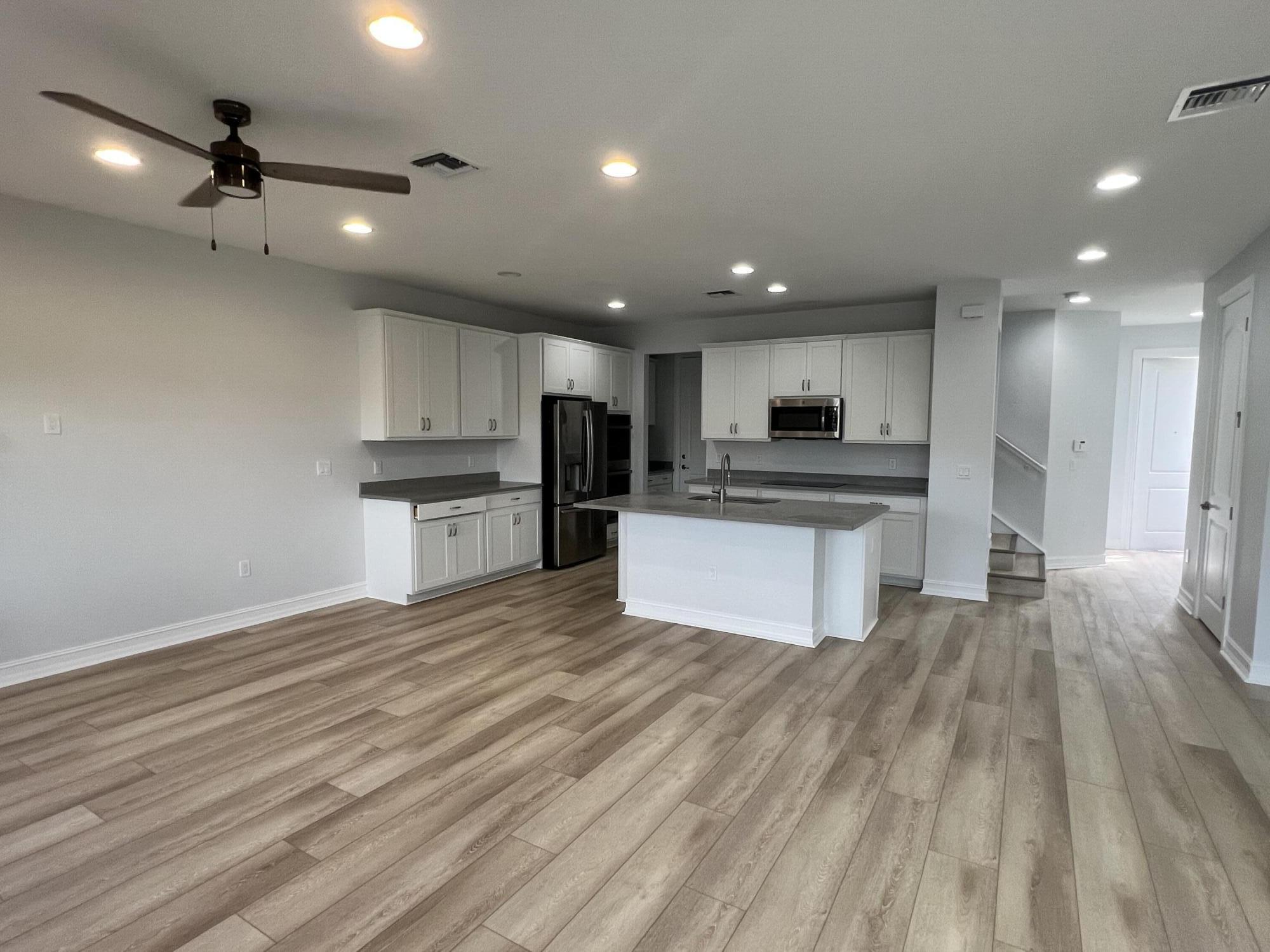 10043 Akenside Drive Boca Raton, FL 33428 - Photo 9 of 30 a large kitchen with kitchen island a stove a refrigerator cabinets and wooden floor