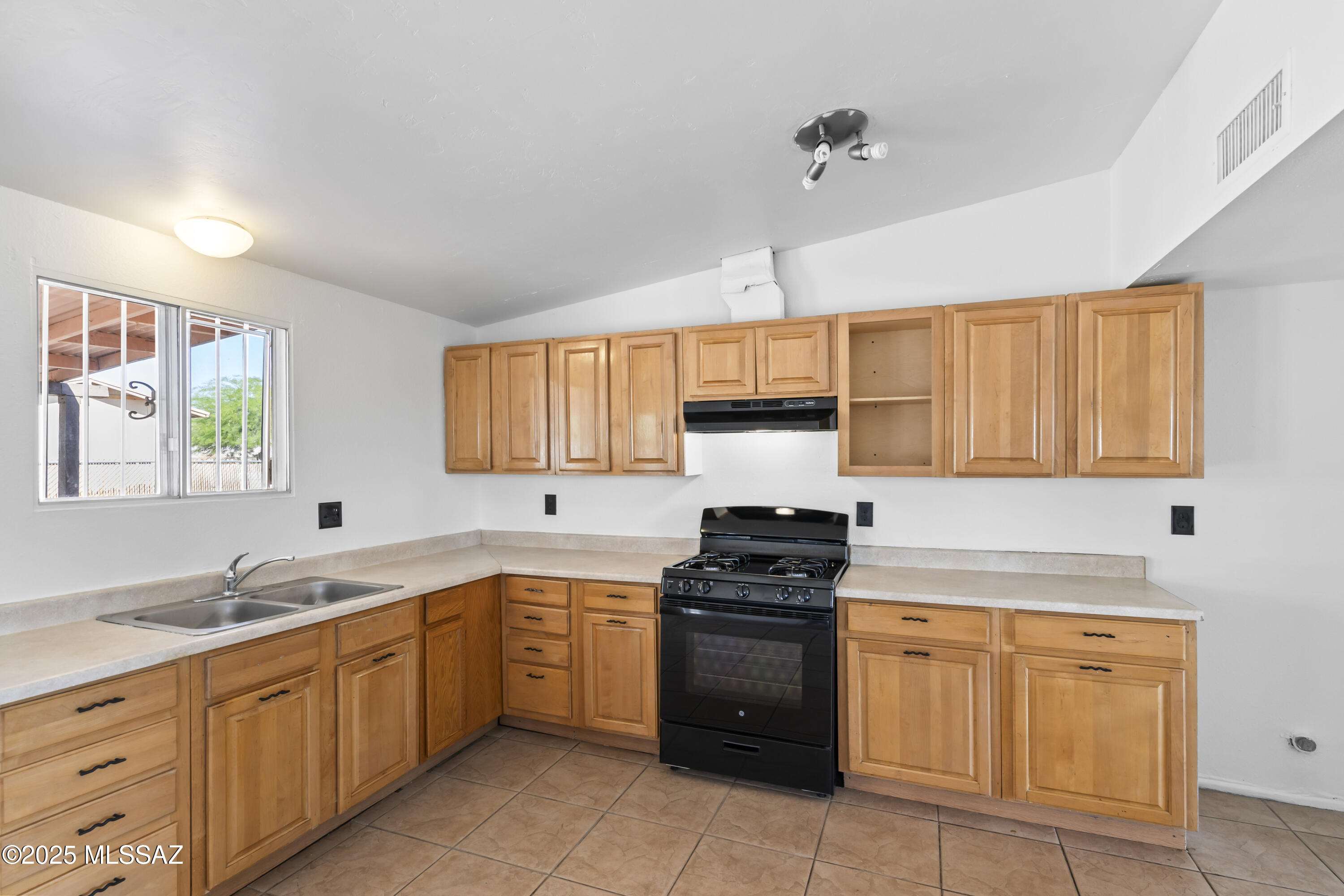 1926 West Saxony Road Tucson, AZ 85713 - Photo 14 of 26 a kitchen with stainless steel appliances a sink stove and cabinets