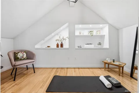a bedroom with a bed and a table with wooden floor