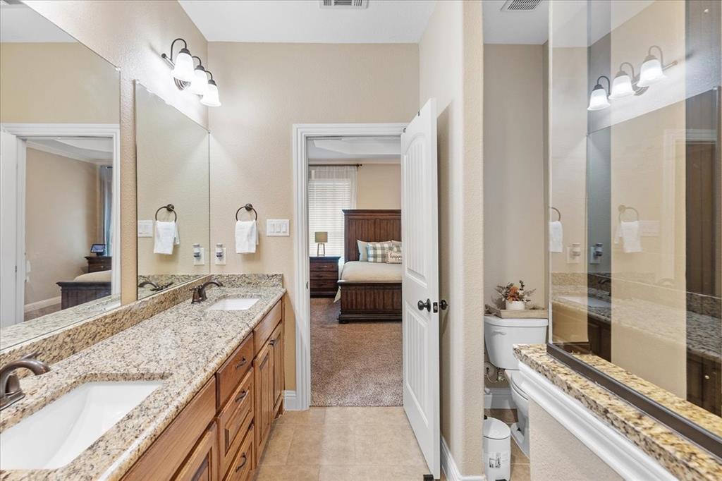 502 Ritchey Street Gainesville, TX 76240 - Photo 23 of 29 a bathroom with a granite countertop sink a mirror and a shower