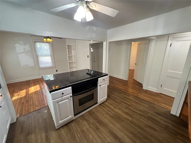 a kitchen with granite countertop wooden floors and stainless steel appliances