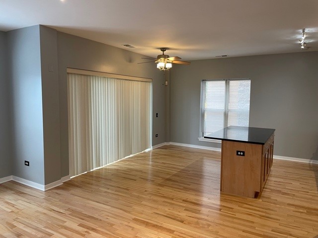 1075 West Roosevelt Road, Unit 209 Chicago, IL 60608 - Photo 3 of 16 a view of an empty room with window and wooden floor