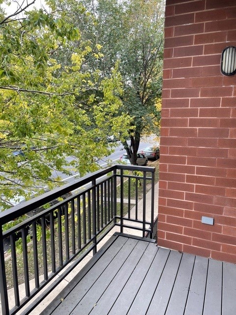 1075 West Roosevelt Road, Unit 209 Chicago, IL 60608 - Photo 9 of 16 a view of a balcony with wooden floor