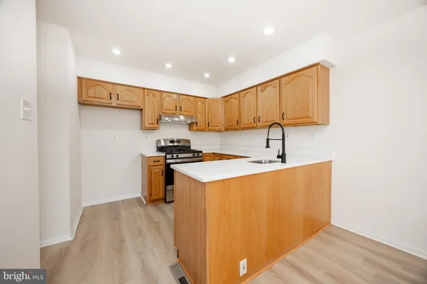 a kitchen with a sink a stove a refrigerator and a window