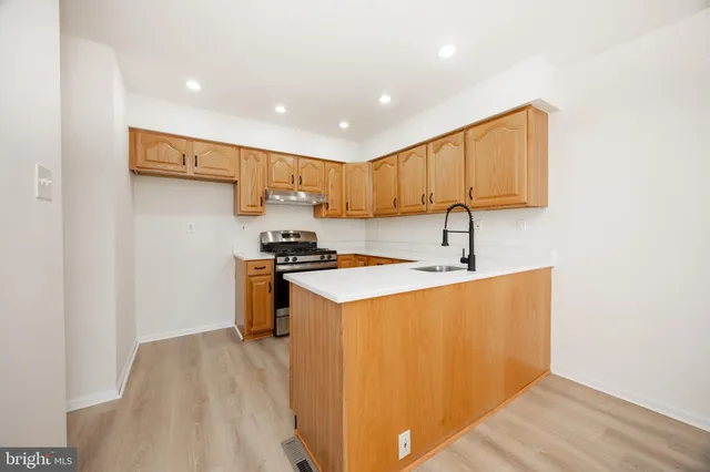 a kitchen with a sink a stove a refrigerator and a window