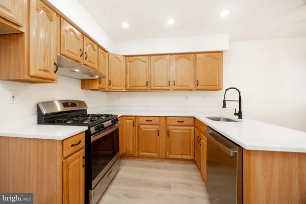 a kitchen with stainless steel appliances granite countertop a sink stove and cabinets