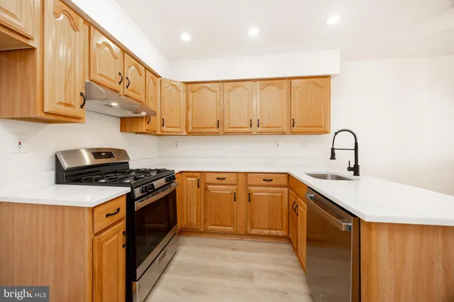 a kitchen with stainless steel appliances granite countertop a sink stove and cabinets