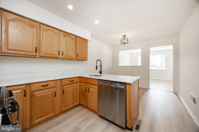a kitchen with stainless steel appliances granite countertop a sink and cabinets with wooden floor