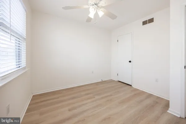 an empty room with a window and a fan