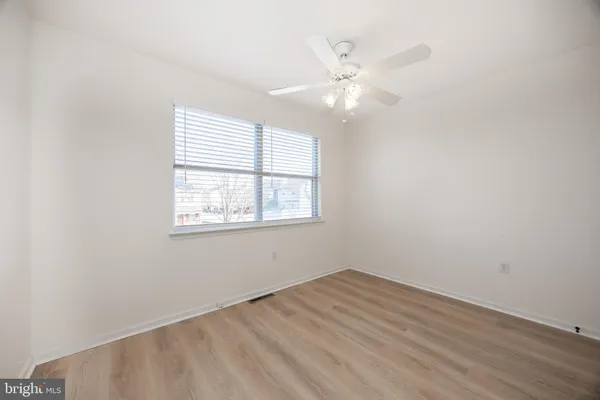 an empty room with a window and wooden floor