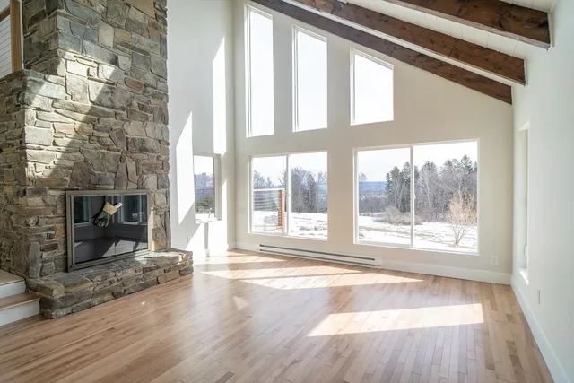a view of an empty room and wooden floor fire place