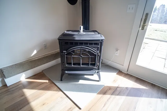 a view of a hallway with wooden floor and a bathroom