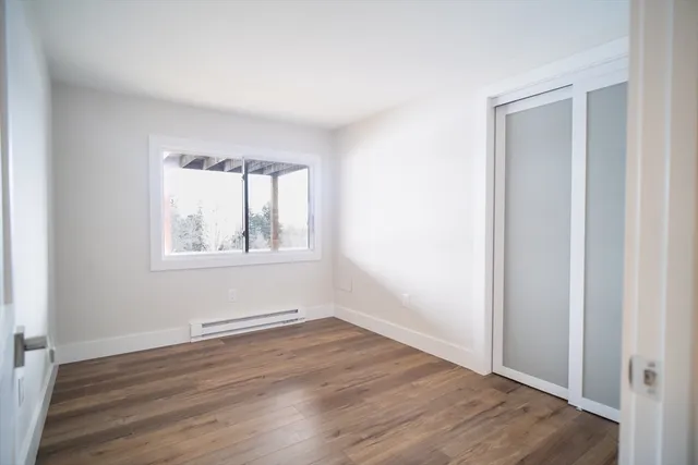 an empty room with wooden floor and closet