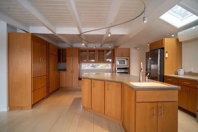 a kitchen with stainless steel appliances granite countertop a sink and dishwasher with white cabinets