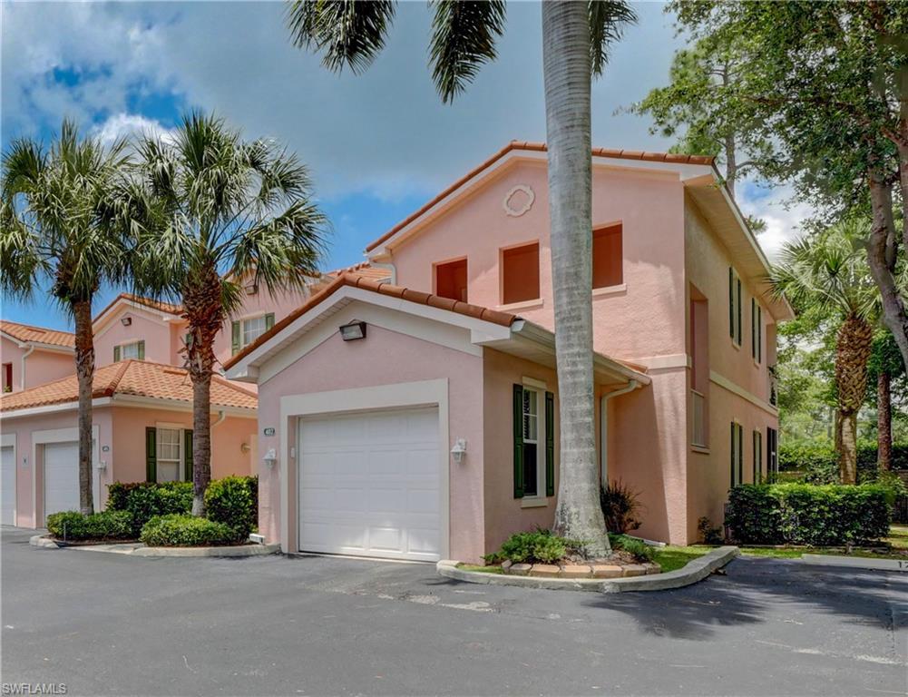 990 Peggy Circle, Unit 404 Naples, FL 34113 - Photo 1 of 26 a front view of a house with a garden and plants