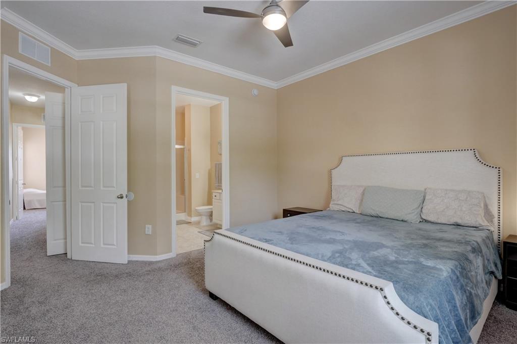 990 Peggy Circle, Unit 404 Naples, FL 34113 - Photo 13 of 26 a bedroom with a large bed and a chandelier fan