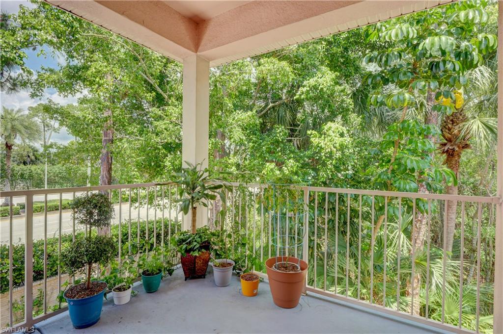 990 Peggy Circle, Unit 404 Naples, FL 34113 - Photo 21 of 26 a view of a balcony with chair and potted plants