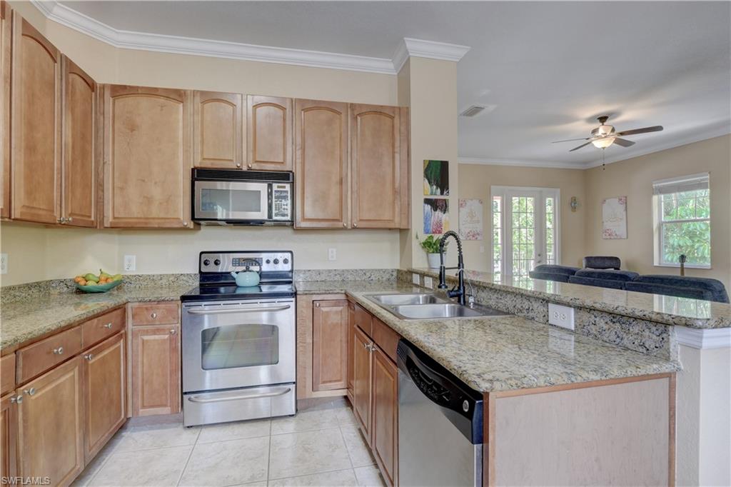 990 Peggy Circle, Unit 404 Naples, FL 34113 - Photo 8 of 26 a kitchen with stainless steel appliances granite countertop a sink stove and cabinets