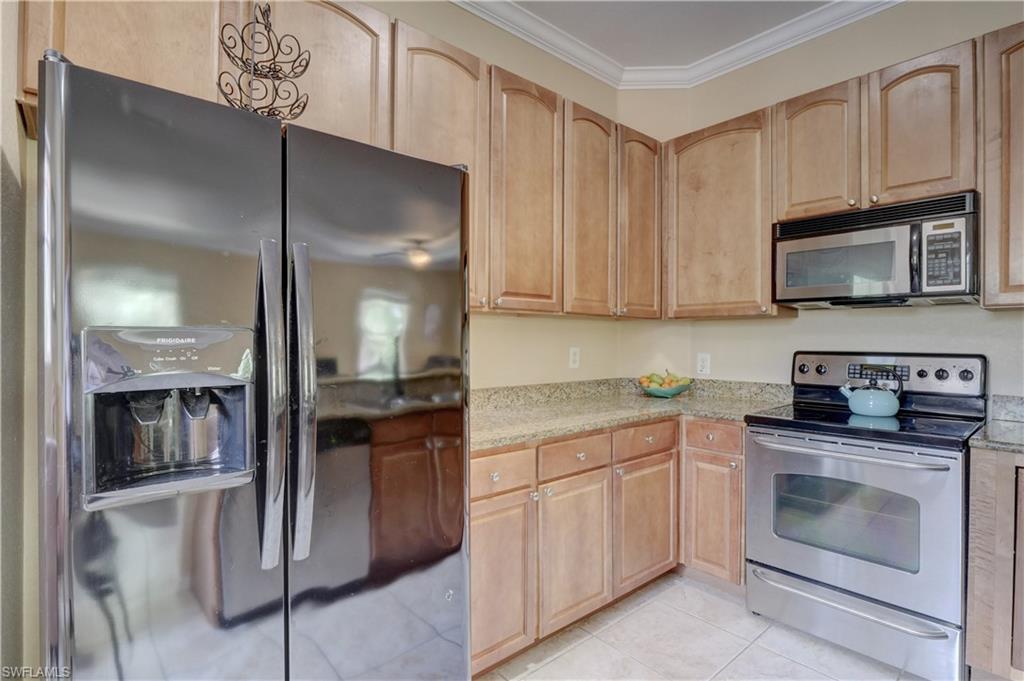 990 Peggy Circle, Unit 404 Naples, FL 34113 - Photo 9 of 26 a kitchen with cabinets stainless steel appliances and sink