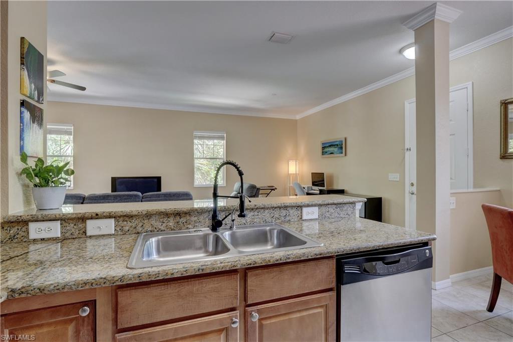 990 Peggy Circle, Unit 404 Naples, FL 34113 - Photo 10 of 26 a kitchen with granite countertop a sink and cabinets