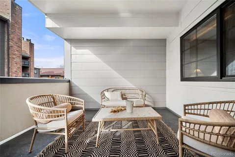 a balcony with a table and chairs