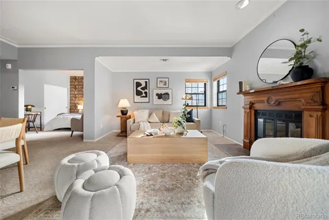 a living room with furniture a fireplace and a large window