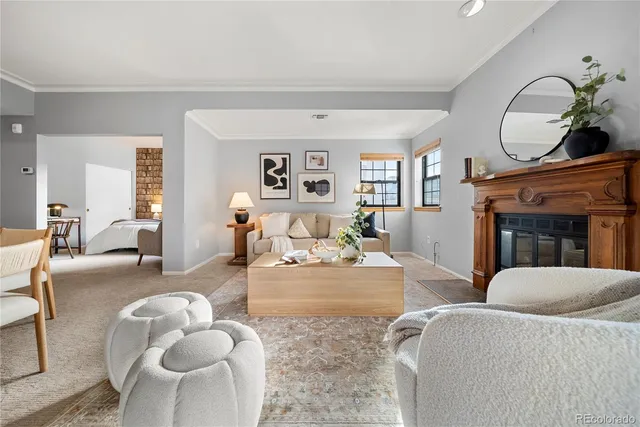 a living room with furniture a fireplace and a large window