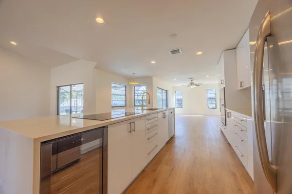 a large kitchen with a lot of counter space and wooden floor