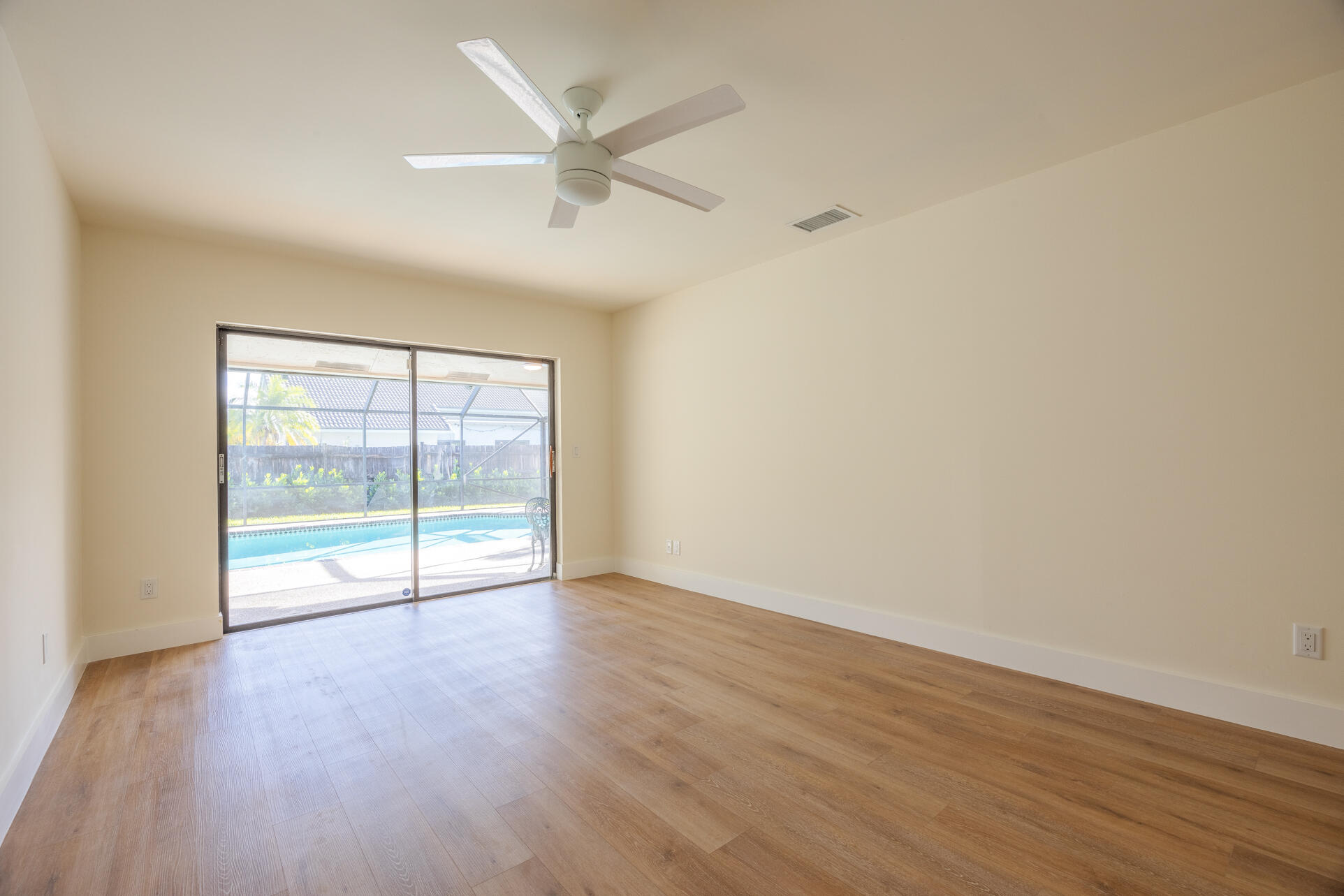 22352 Martella Avenue Boca Raton, FL 33433 - Photo 4 of 26 an empty room with wooden floor and windows