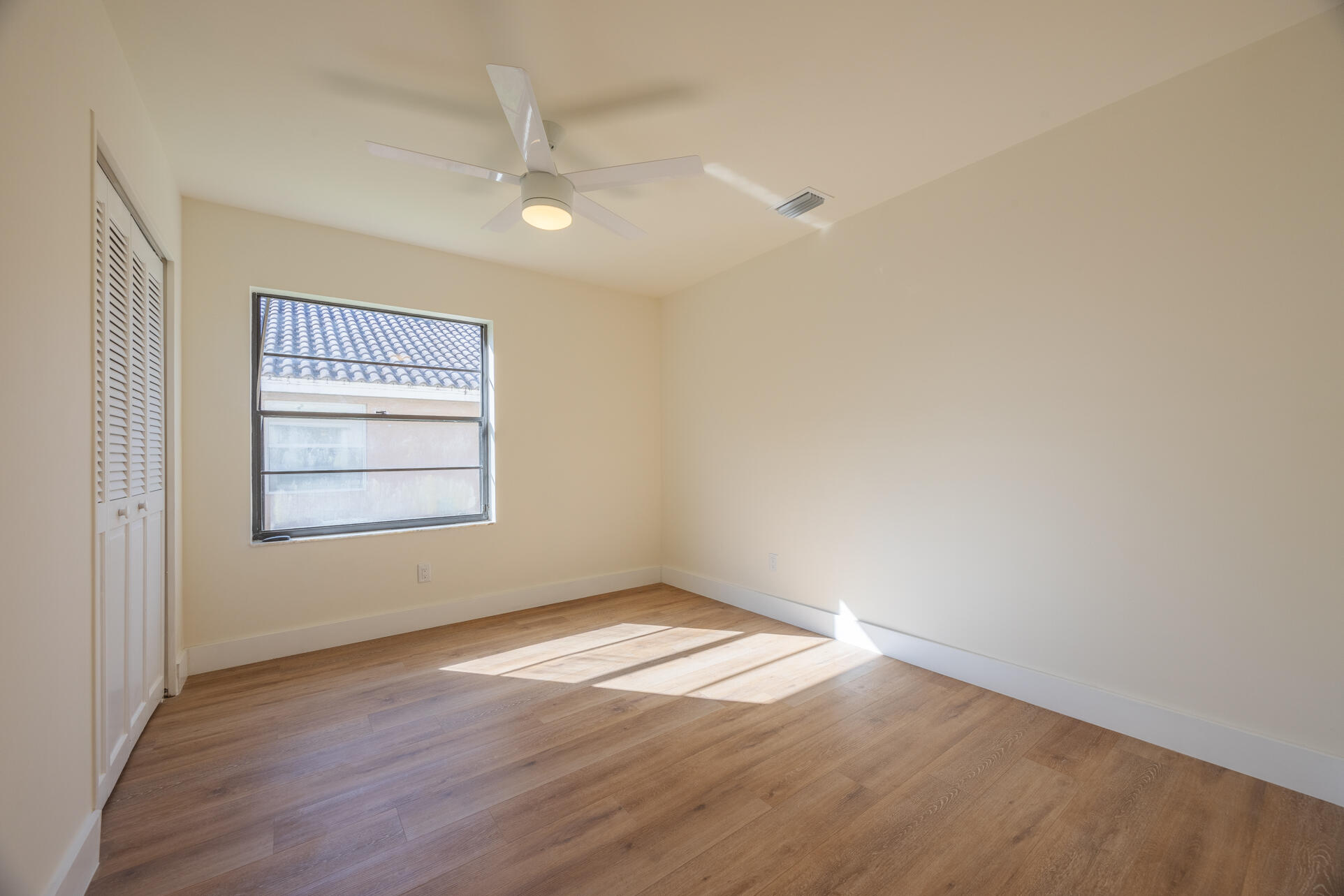 22352 Martella Avenue Boca Raton, FL 33433 - Photo 9 of 26 an empty room with wooden floor and windows