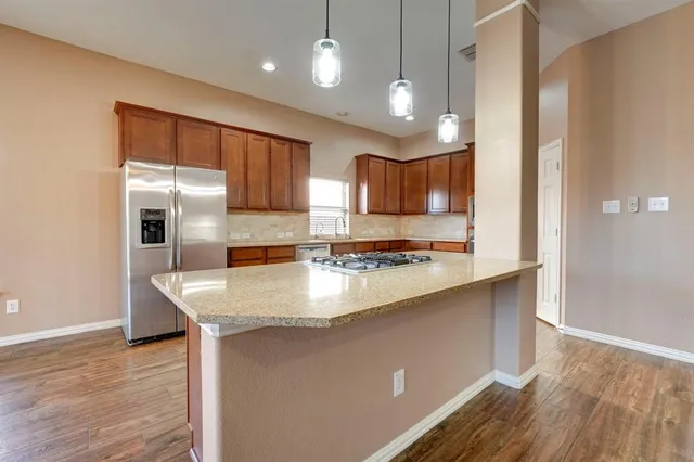 a kitchen with stainless steel appliances granite countertop a sink stove and refrigerator